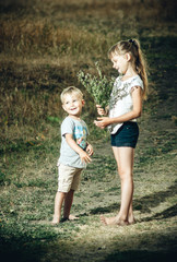 Fototapeta premium older sister plays with brother in nature
