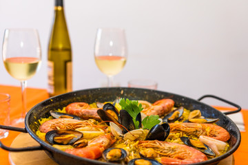 Seafood paella on an orange background