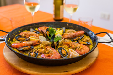 Seafood paella on an orange background