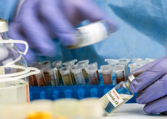 Nurse shakes vial mixing medication Coronavirus covid-19 experimental vaccine in a laboratory,...