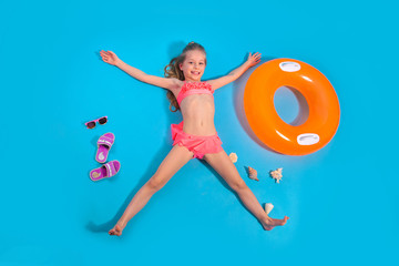 Pretty little girl relaxes with inflatable circle. Summer travel concept.