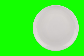 White flat plate isolated on green background, top view, copy space.