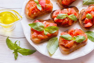 Bruschetta with tomatoes and Basil on a plate top view