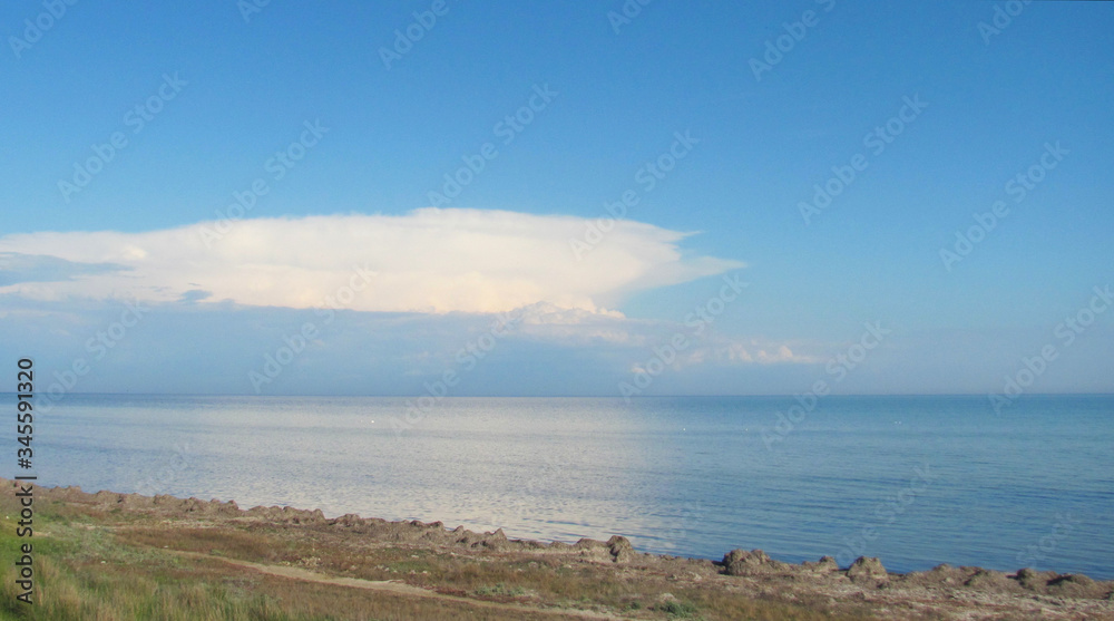 Wall mural view from the shore to the sea and clouds