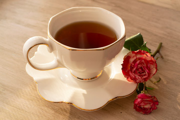 Healthy tea in white classic cup with roses, vintage image