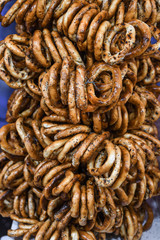 German pretzels stack one over each other, group of thin dry pretzels on rope