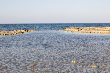A beautiful landscape of a beach with rocks and crystalline waters
