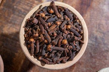 Indian spices collection, dried aromatic cloves flower buds and another spices in clay bowls