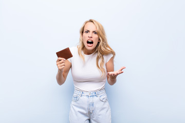 young blonde woman looking angry, annoyed and frustrated screaming wtf or what‚Äôs wrong with...