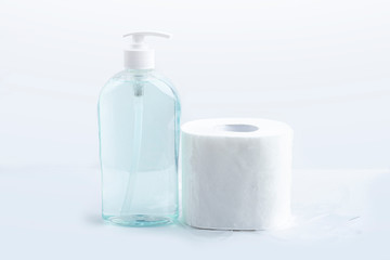 Hygienic set of toilet paper roll, disposable plastic gloves and bottle with antiseptic sanitizer gel. Hygiene products. Protection during the coronavirus epidemic. Copy space for text, close up