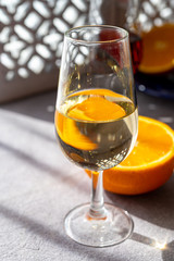 Glass with cold fino sherry fortified wine in sunlights, andalusian style interior on background