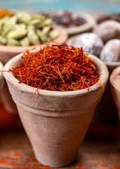 Fototapeta premium Indian spices collection, dried red saffron and another spices in clay bowls