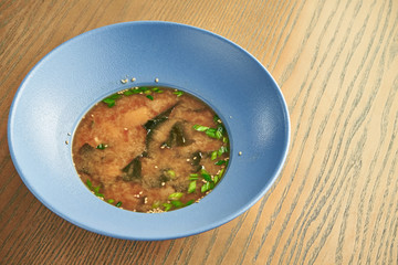 Traditional japanese miso soup in a blue bowl on a wooden background. Healthy, Dietary Food. Close up