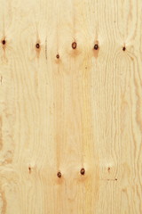 hellbraune Holzwand an einem Bauzaun mit Astlöchern