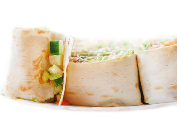 Pita rolls with tomatoes, green lettuce, cucumber and meat.