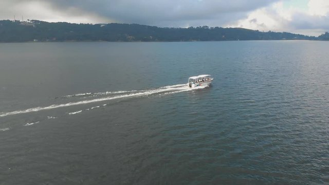 4k Aerial Tracking Shot of a Speed Boat with people moving around a huge lake