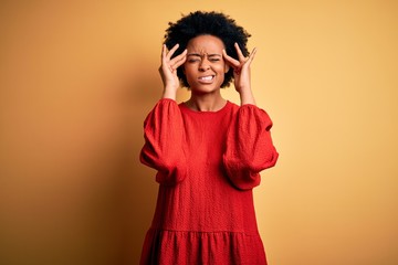 Young beautiful African American afro woman with curly hair wearing casual sweater suffering from headache desperate and stressed because pain and migraine. Hands on head.