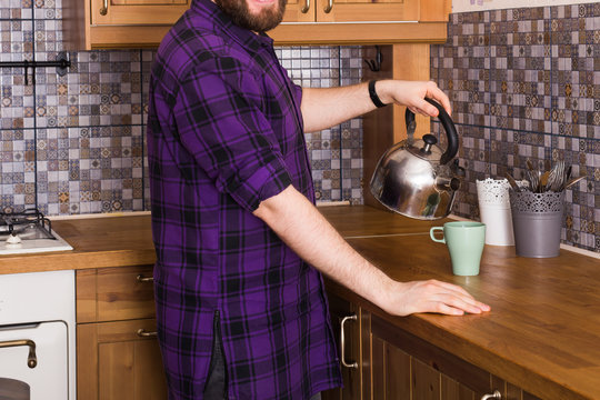 Close-up Of Man With Kettle Making Tea For Breakfast At Home Kitchen. Morning And Breakfast Concept.