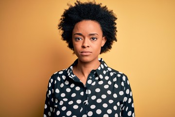 Obraz na płótnie Canvas Young beautiful African American afro woman with curly hair wearing casual shirt standing with serious expression on face. Simple and natural looking at the camera.