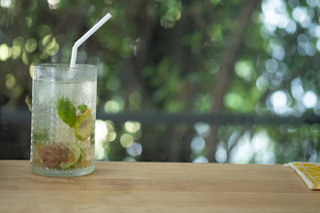 Iced plum juice mixed with lemon and soda on wooden table.