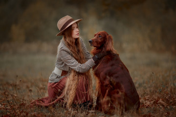Beautiful long-haired blonde young woman in English style with Irish setter and Weimaraner dogs in...