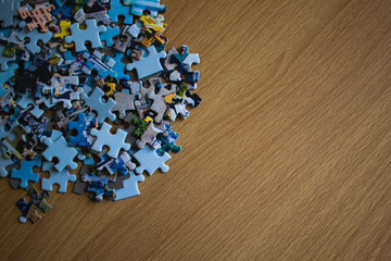Close -up puzzle pieces piled up on a wooden table