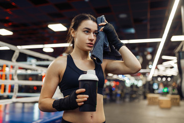 Tired woman wipes her sweat after boxing training