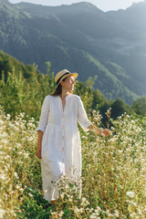 a happy girl in a hat walks through a field of daisiesa happy girl in a hat walks through a field of daisies