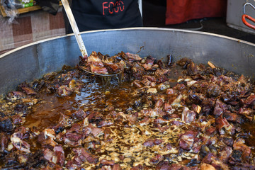 Traditional fish stew being prepared in a rustic bowl over a wood background.