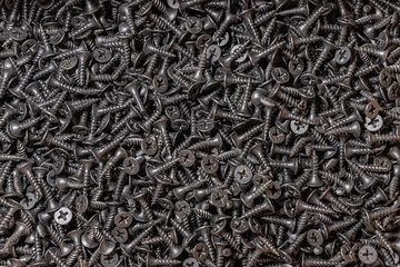 Wood screws. Texture. Background for wallpaper. A lot of black screws. View from above.