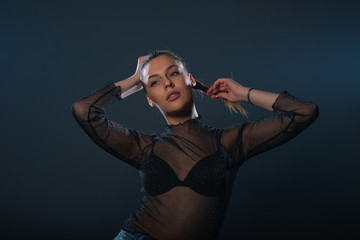 Fashion portrait of an attractive brunette girl holding and pulling her ponytail.