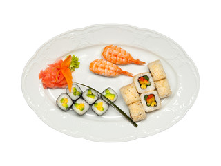 Sushi with shrimps and rolls with cucumber, avocado, paprika and nori. Pickled ginger and wasabi on white oval plate