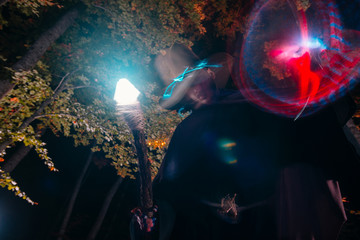 Wizard (mage) casting a spell with his magical staff while standing in an enchanted forest..