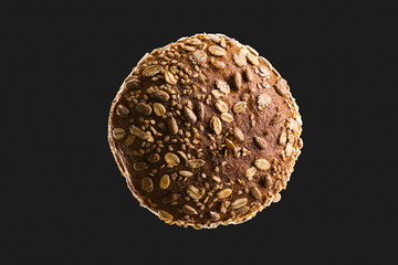 Top view macro of bread isolated on black background. Dark and moody food concept