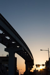 オレンジ色の夕日とモノレールの軌道