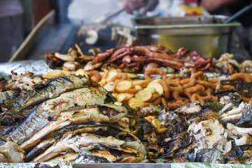 Freshly grilled fish on counter top stall, during seafood festival, street food market.