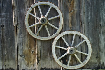 wooden wheels in front of a wooden wall