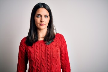 Young brunette woman with blue eyes wearing casual sweater over isolated white background Relaxed...