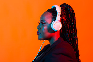 Neon portrait of young black woman listen to music in headphones.