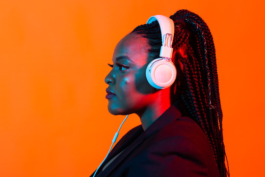 Neon Portrait Of Young Black Woman Listen To Music In Headphones.