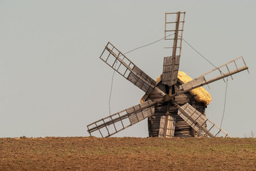 Fototapeta premium Summer day. Color image. Wide field. Beyond the horizon is visible part of the huge wind mill. Photographed in Ukraine. Kiev region. Horizontal frame.