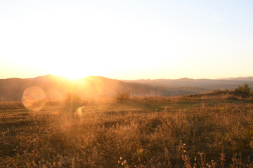 Romantic scenery during autumn sunset. Hills and mountains in the background