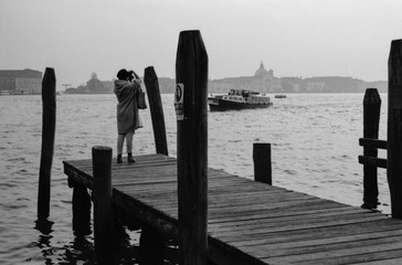 Venice, Italy, elegant woman taking picture of San Marco church in the landscape