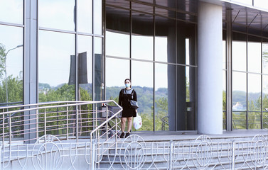 Ukraine Kiev May 2020. Labor day may 1. Woman in protective masks on the street in the context of the coronavirus pandemic COVID-19 near the supermarket building are carrying food purchases.