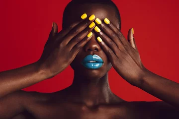 Afrikanische Frau mit buntem Make-up, das ihre Augen bedeckt © Jacob Lund