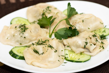 Manti in a white plate. A traditional meat dish of the peoples of Central Asia, Kalmykia, Turkey, Mongolia, Korea, Tatarstan, Bashkortostan, Crimea, Kyrgyzstan, Kazakhstan and China