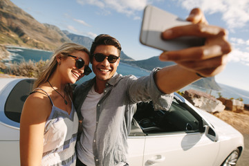 Man taking selfie with his woman on a road trip