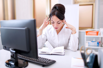 young doctor woman at medical office with hand on the head thinking about question, pensive expression. Doubt concept.