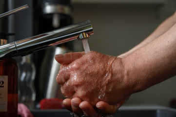 Man washing his hands under running water