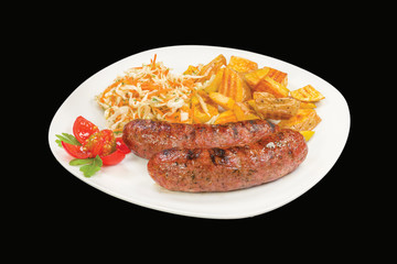 Tasty fresh grilled sausage served with potatoes and cabbage , on a white plate, isolated on black background